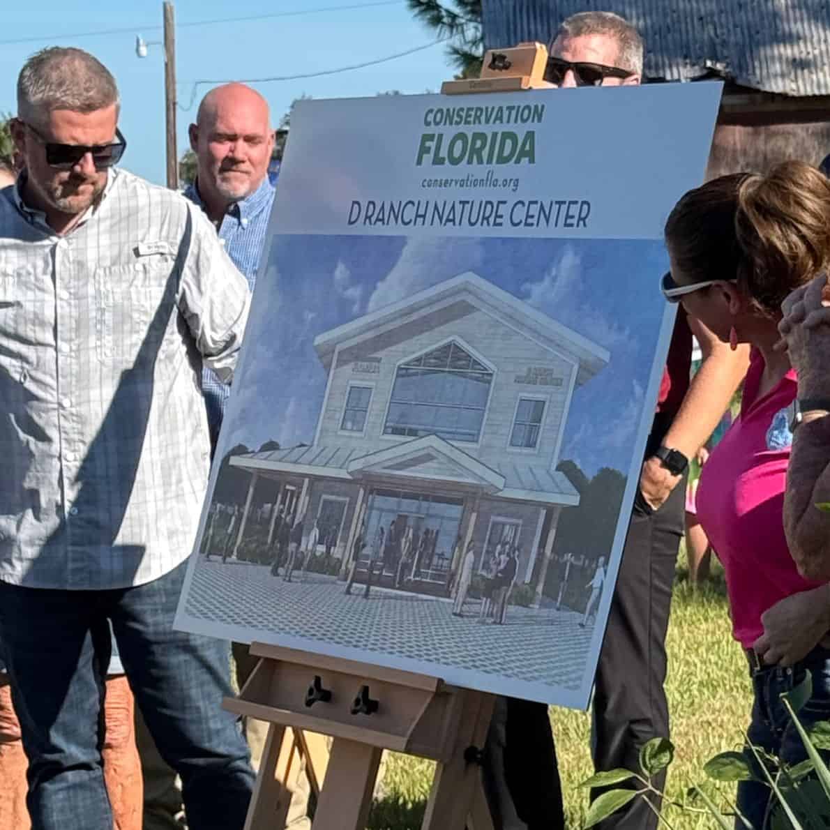 Group of people viewing an easel display showing the Conservation Florida D Ranch Nature Center building design.