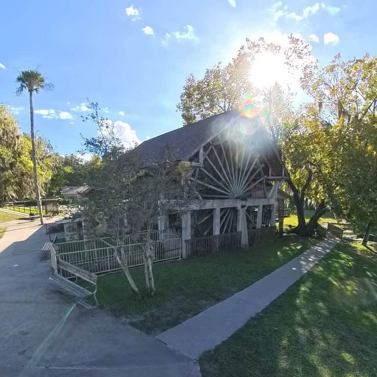 The Old Sugar Mill Pancake House with its wooden waterwheel surrounded by trees at De Leon Springs State Park.