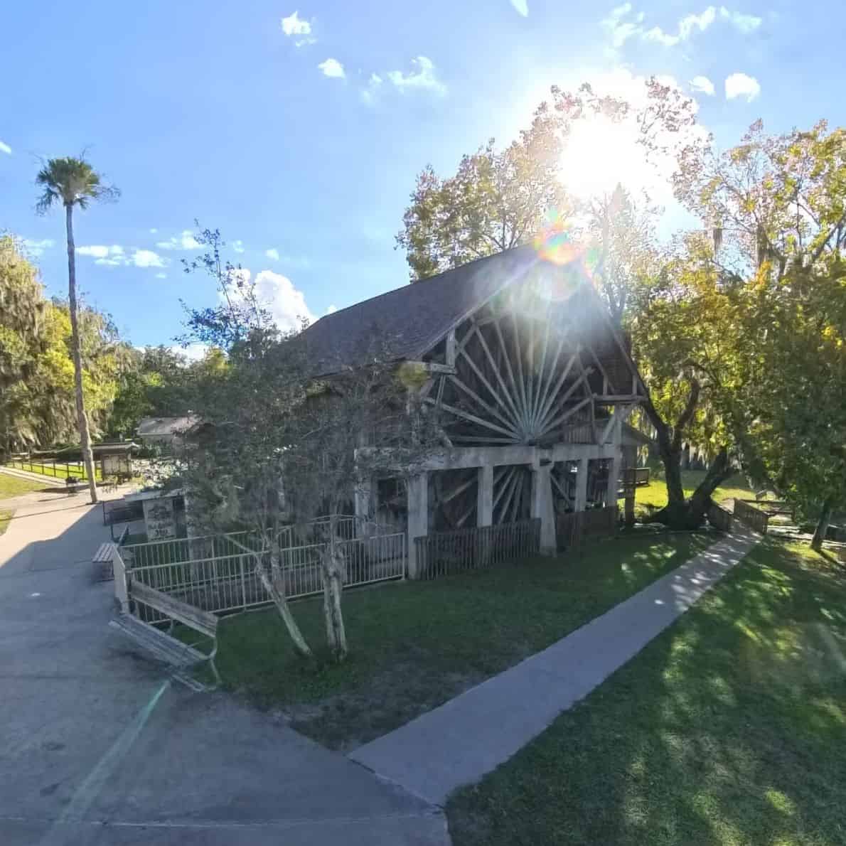 The Old Sugar Mill Pancake House with its wooden waterwheel surrounded by trees at De Leon Springs State Park.
