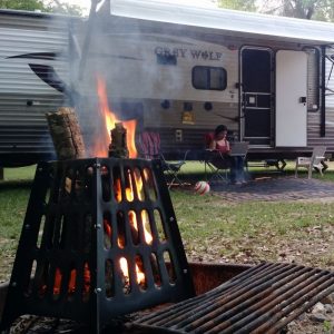 Campfire burning beside a travel trailer at a Florida campground.